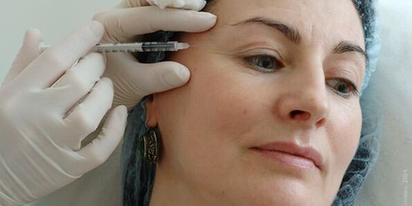 Seringue à côté du visage d'une femme